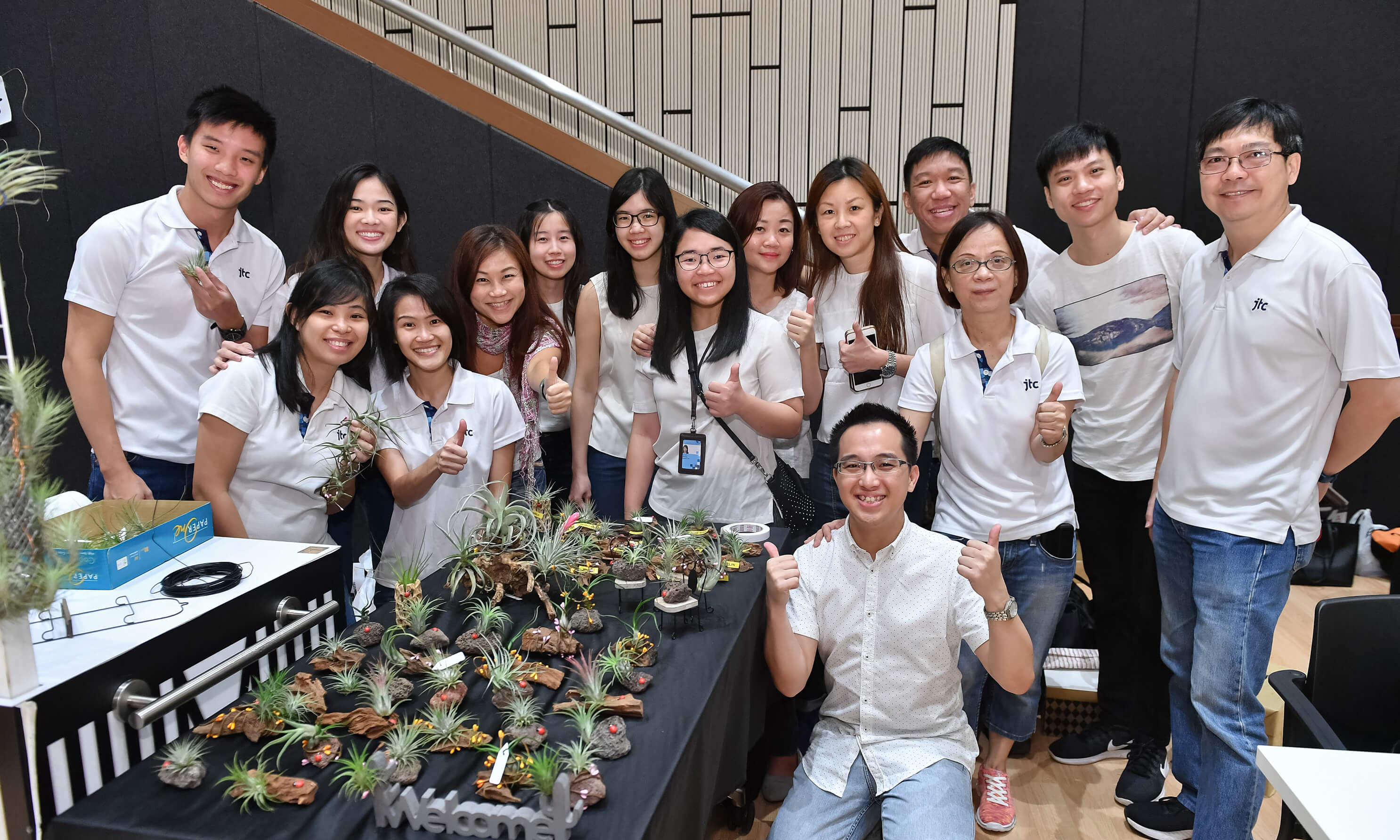 A group of people posing with their tiny planters