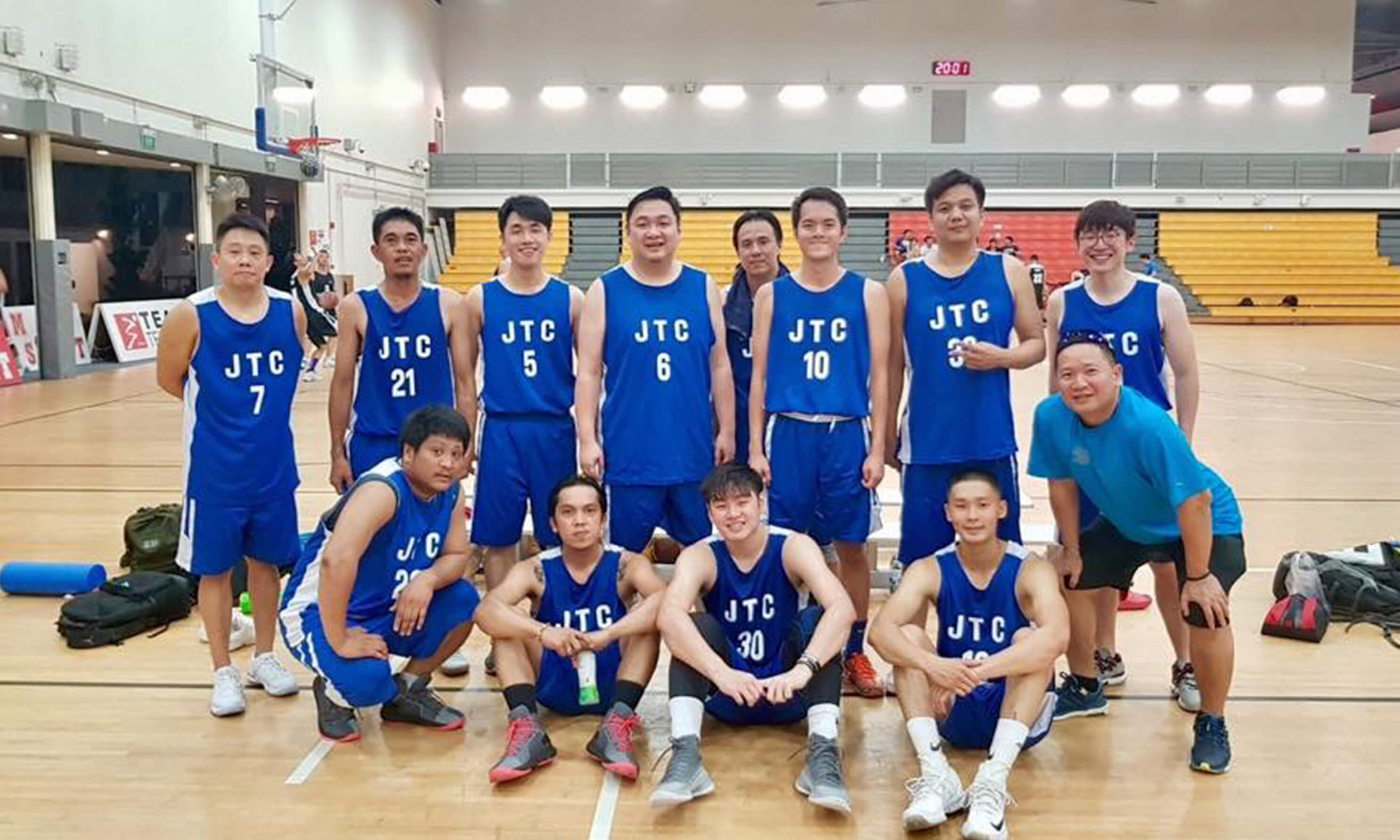 A team of basketball players from JTC at an indoor basketball court