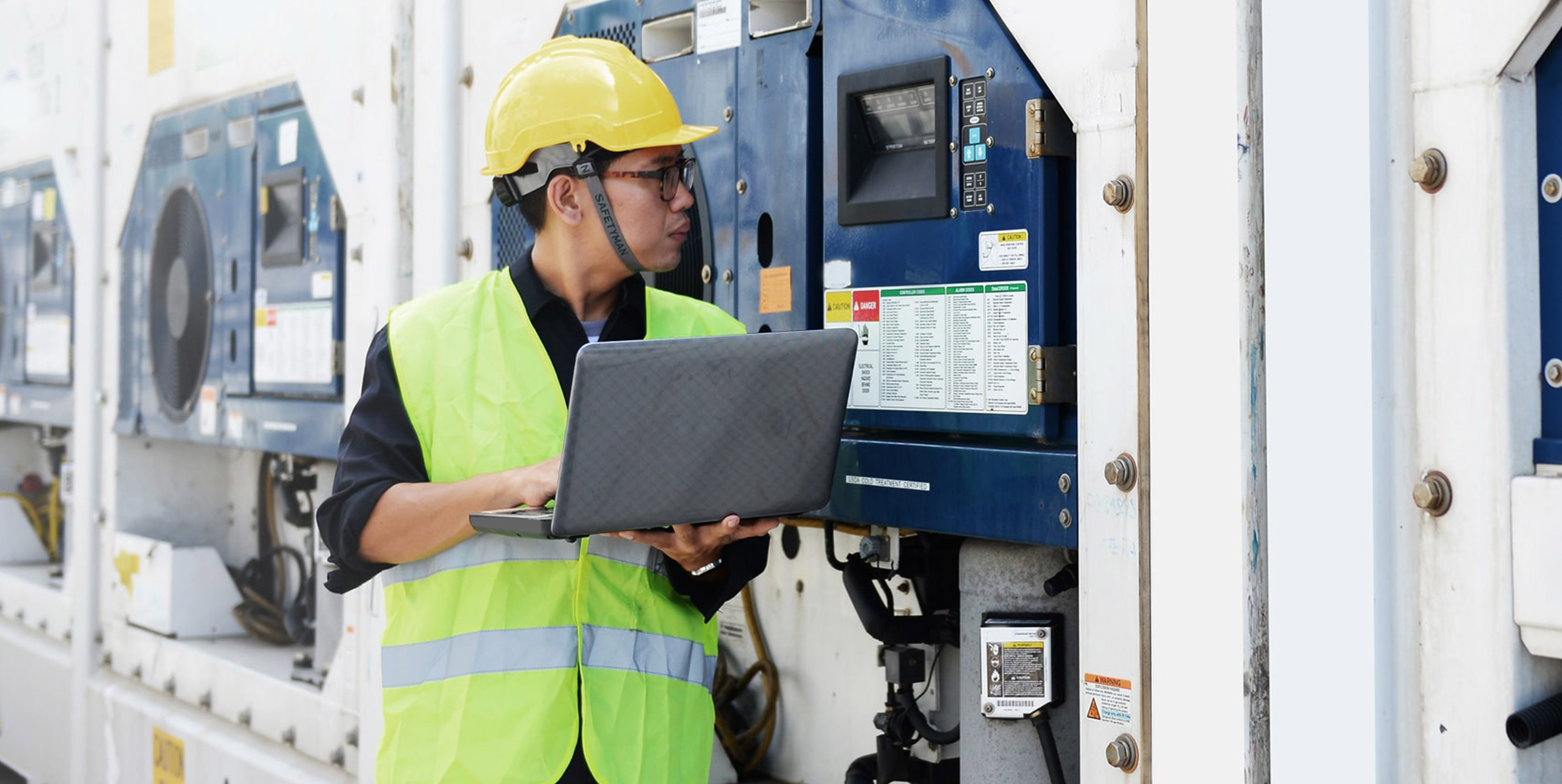 Man in a safety helmet and safety vest doing checks on equipment