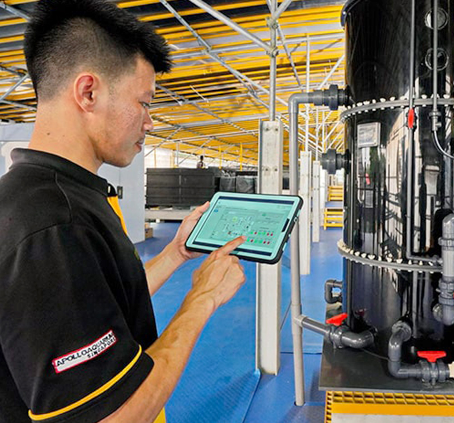 Man uses a tablet device to perform checks on advanced manufacturing equipment