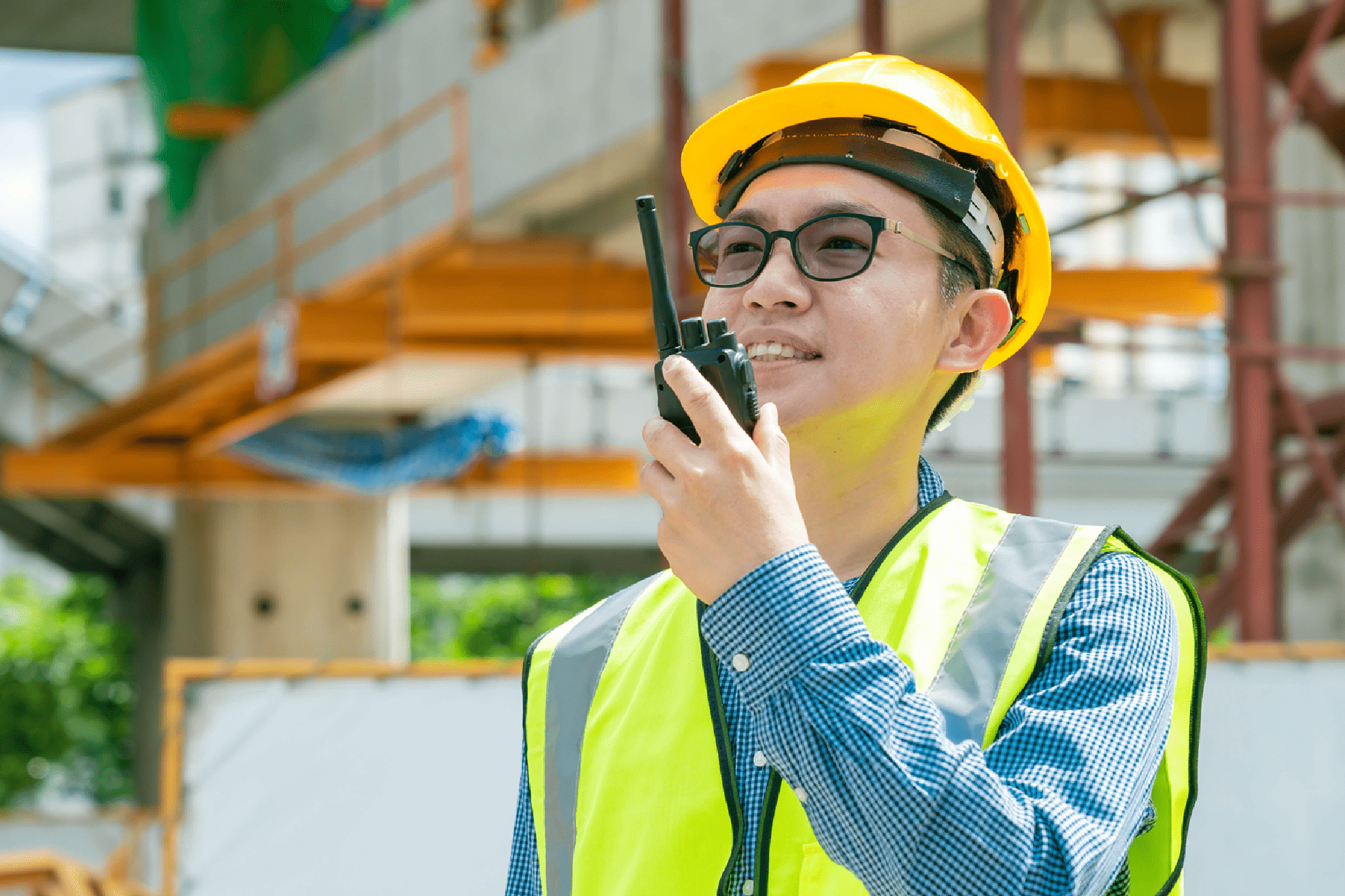 Man wearing reflective vest talking through a walkie-talkie