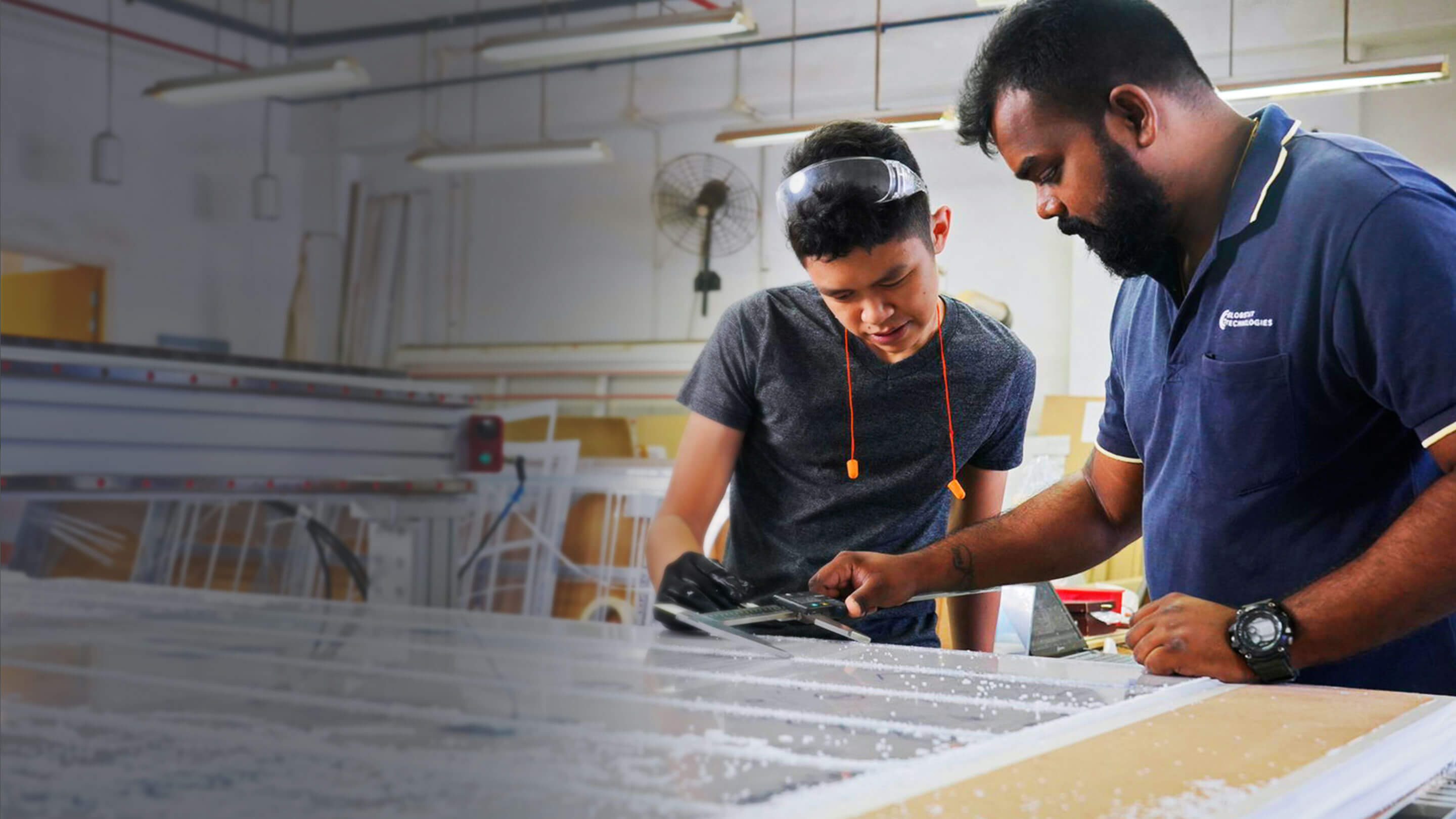 Employees taking measurements of manufacturing materials 