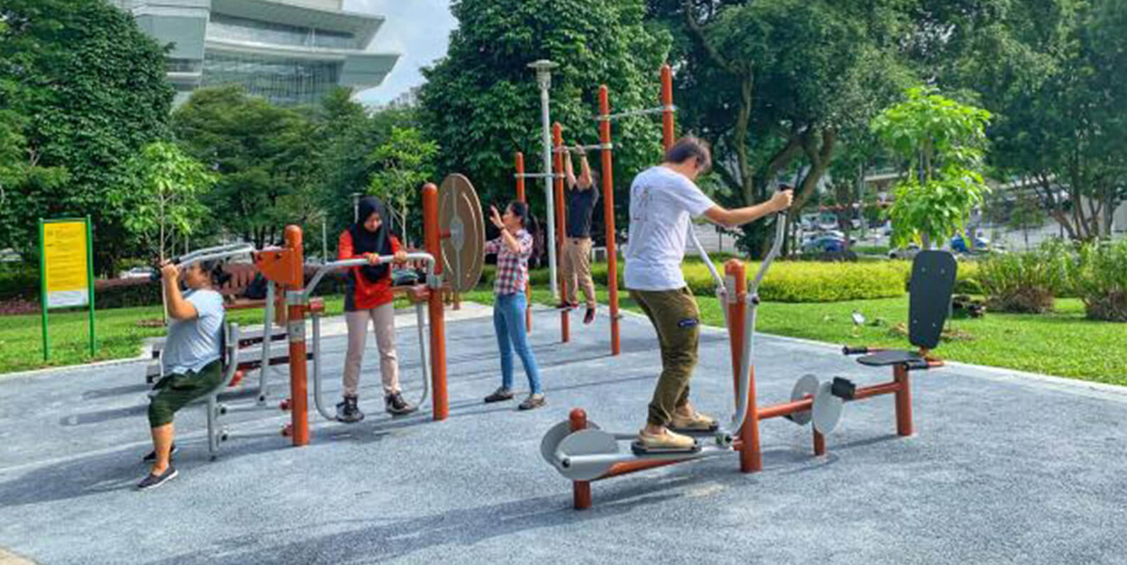 A group of people exercising using outdoor fitness equipment