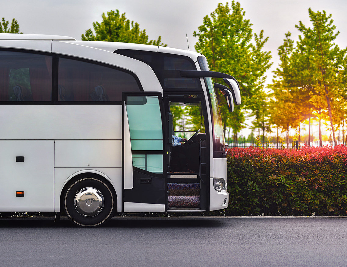 A white bus with its door open for boarding
