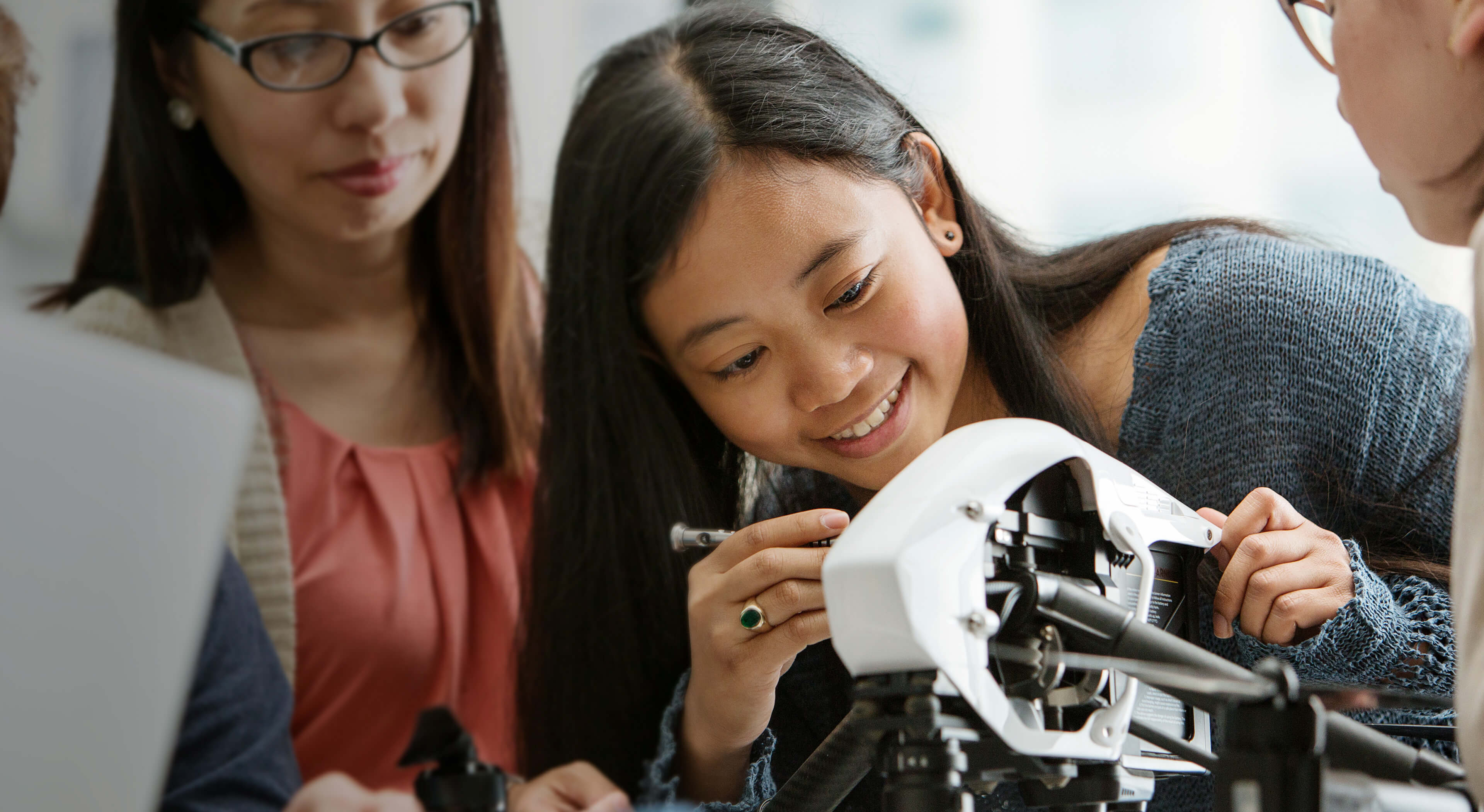 A girl in a team setting making adjustments to a device