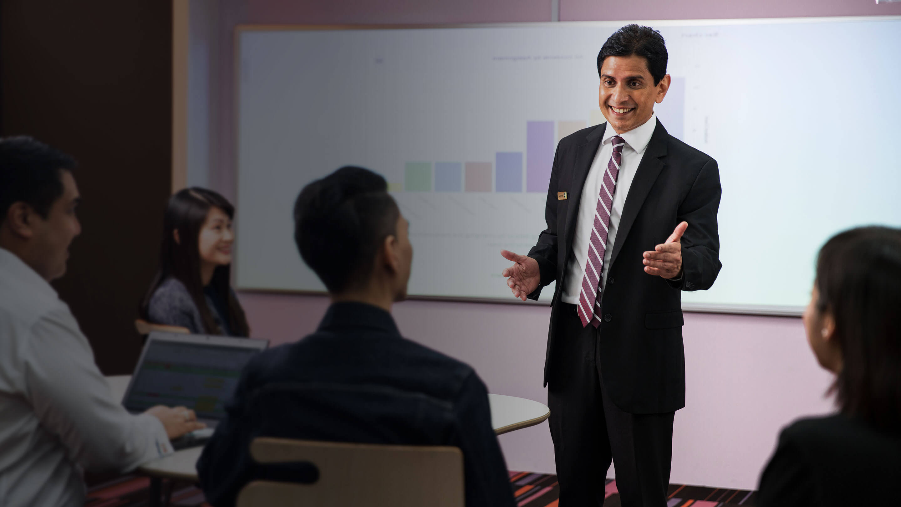 A man conducts a presentation to a team of professionals