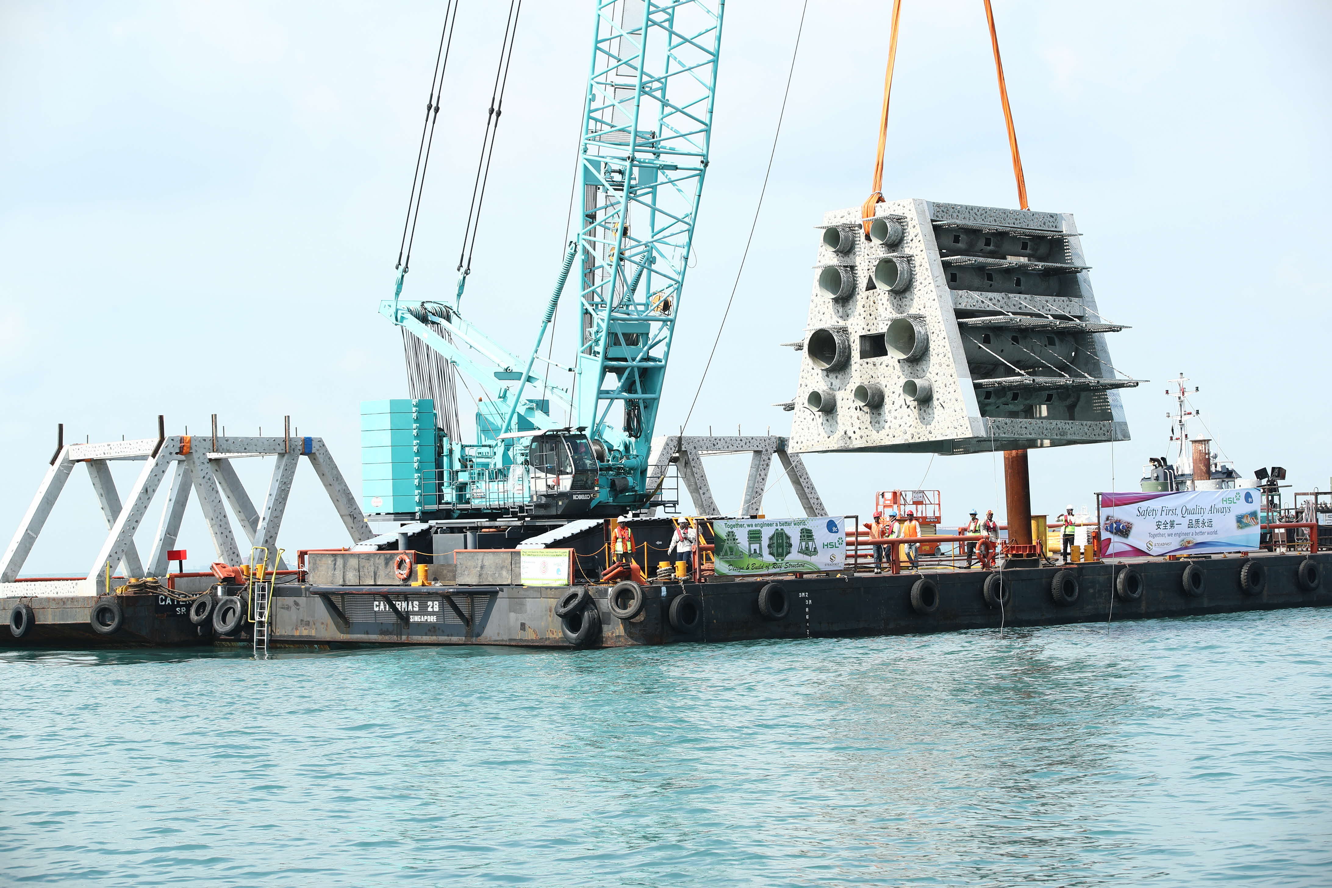 Crane hoisting JTC artificial reef structure at Sister’s Island 