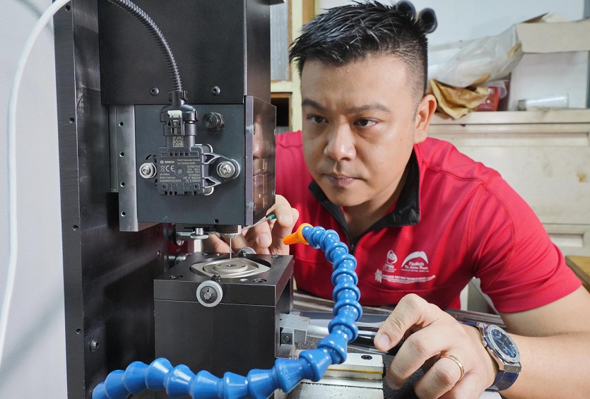 Mr Tan Ru Jin, Managing Director of Flexmech operating the legacy machine installed with sensors that track the machine’s acoustics and vibrations.