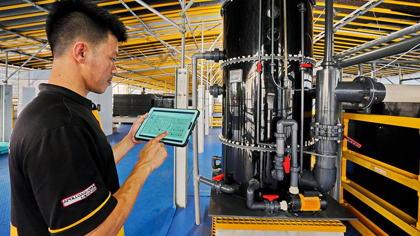 An employee using a centralised, cloud-based system with automated sensors to monitor and optimise aquaculture farms.