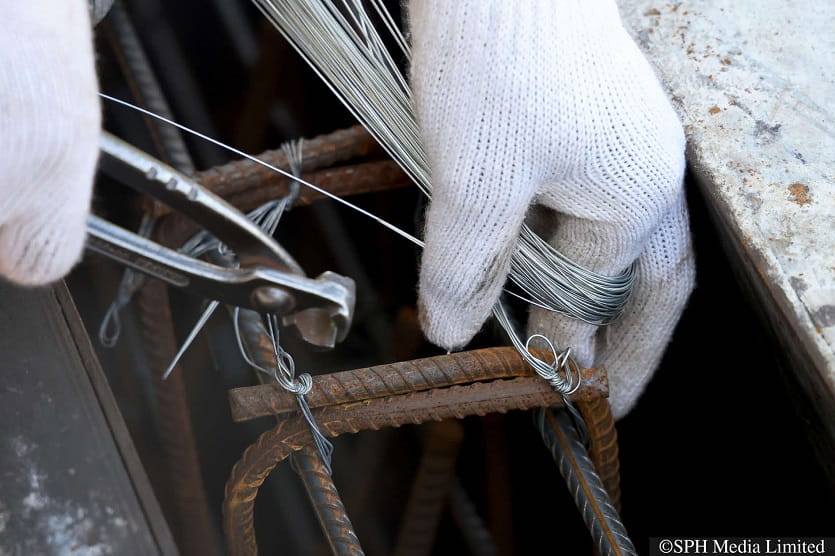 A worker securing reinforcing bars of the bridge planter wall at the Coninco