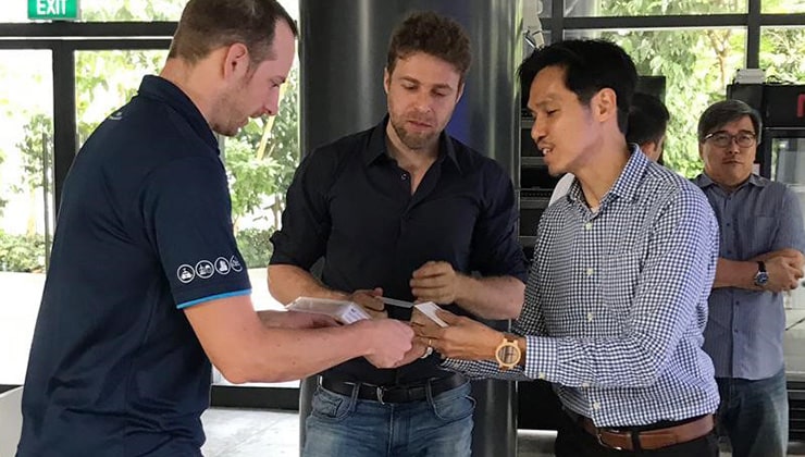 Three professionals exchange business cards