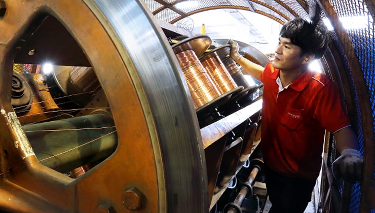 Man operates a machine manufacturing cables in Singapore